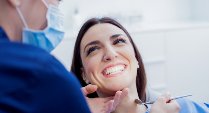 Elegant Young Woman Having Her Teeth Treated In Dental Clinic.