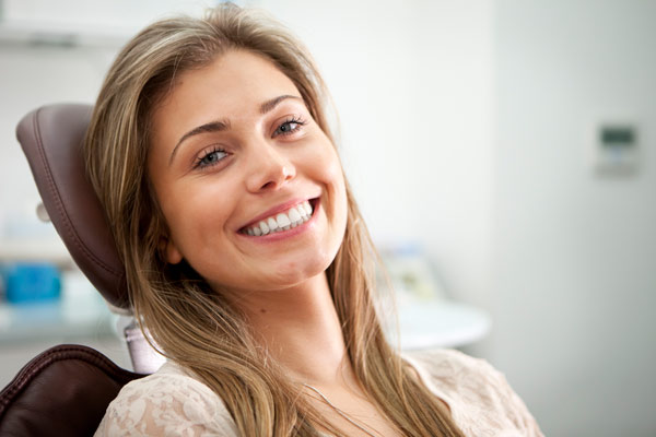 A Young Lady Sitting On Dental Looking Towards The Camera And Smiling