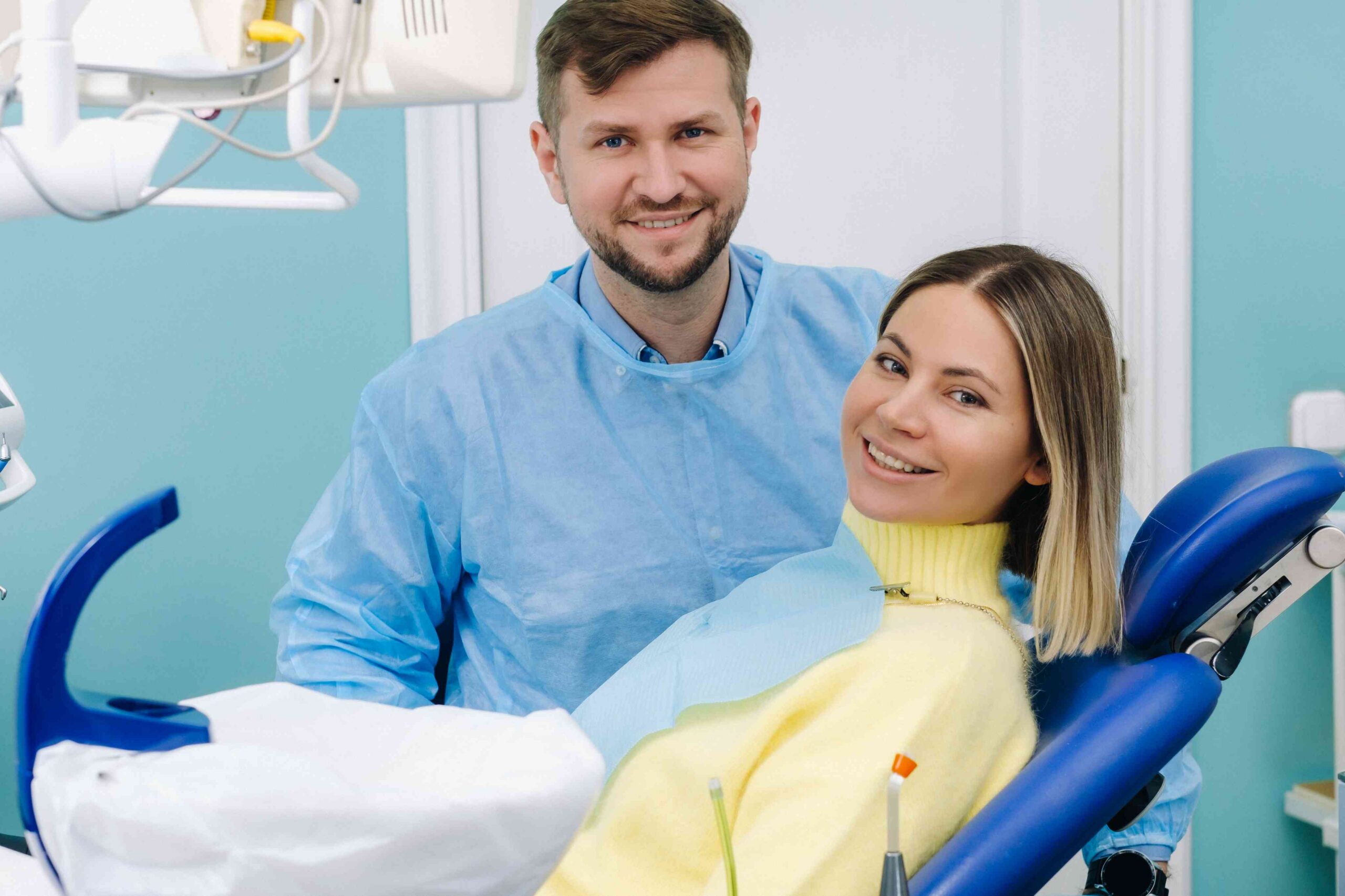 Smiling patient with dentist in a dental exam room.
